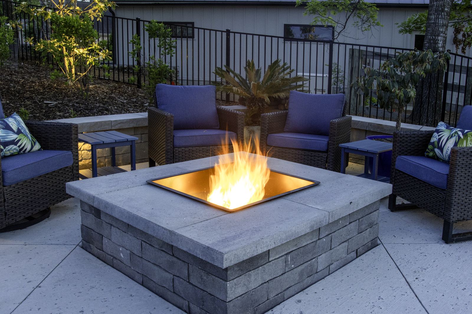 Custom stone fire pit with seating on a backyard patio