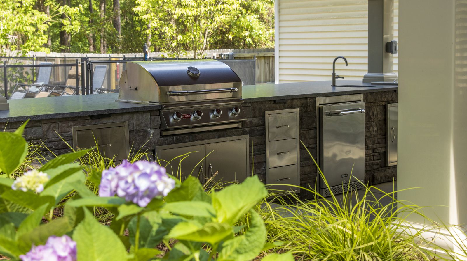 Outdoor kitchen with stone base built under pine trees in the Sandhills